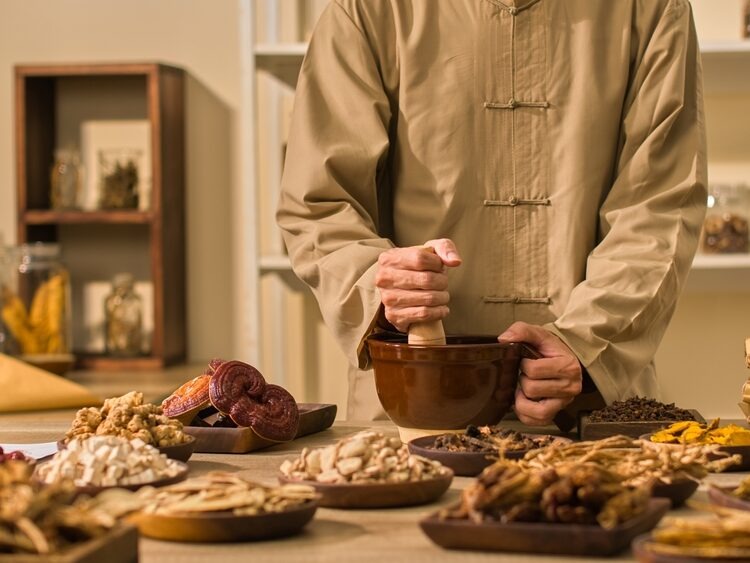 Two,Herbalists,Are,Pounding,Herbs,In,A,Mortar,And,Taking